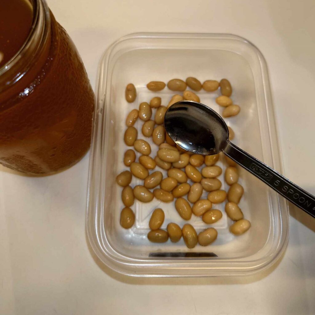 蒸した大豆に納豆菌原液をかける